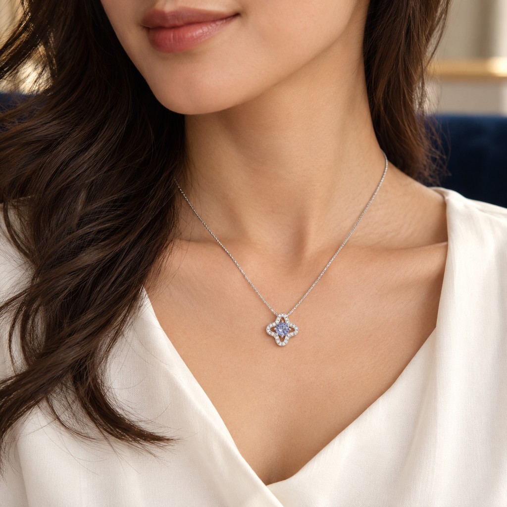 Dije de cuatro lóbulos con piedra azul, puesto en el cuello